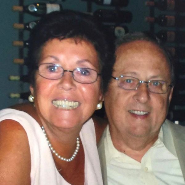Smiling elderly couple wearing glasses.