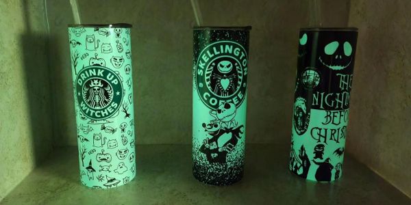 Three glowing Halloween-themed tumblers with spooky designs.