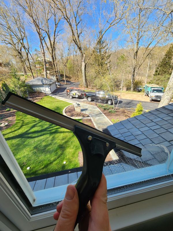 Window cleaning using traditional method of mop and squeegee.