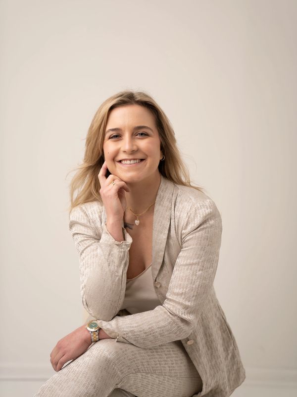 A woman sitting in front of the camera smiling.
