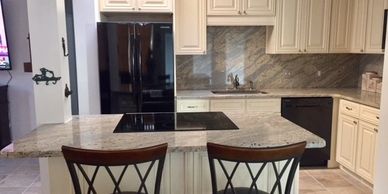 Beautiful small spaced kitchen featuring full granite backsplash. Renovated by Remodeling Contractor