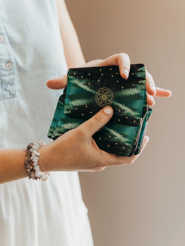 Person holding a deck of mystical cards.