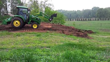 John Deere tractor, moving top soil and levelling ground.