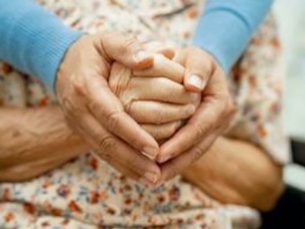 Hands of two people showing care and support.