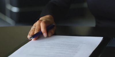a hand with pen on the document 