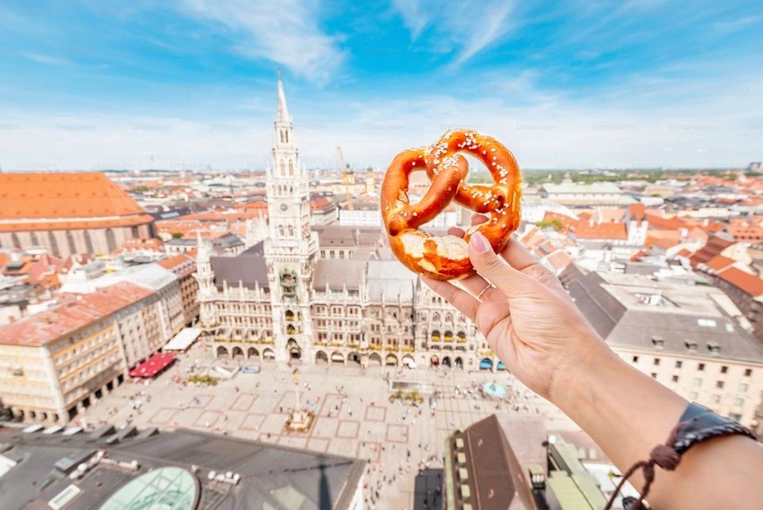 “Munich city view with pretzel in the foreground during Oktoberfest season.”
