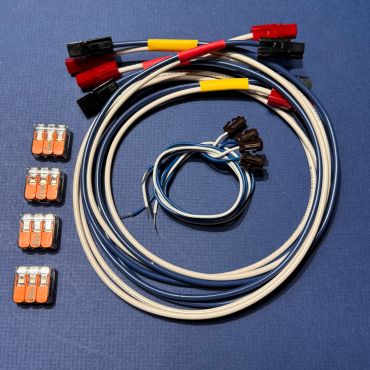 Various electrical wires and connectors arranged on a blue surface.