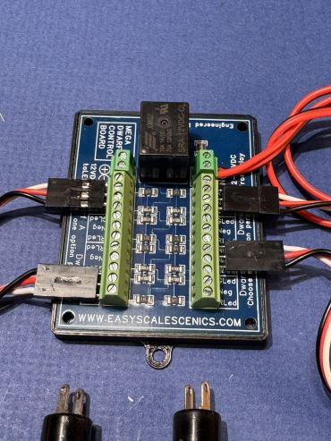 Electronics control board with wiring connections on a blue surface.