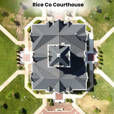 Aerial view of Rice County Courthouse with symmetrical roof and surrounding pathways.