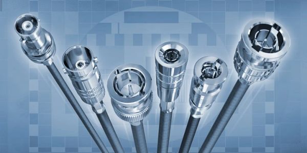 Close-up of various metallic cable connectors against a blue grid background.