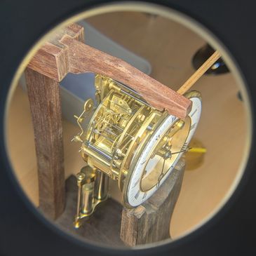 Close-up of a vintage clock mechanism with wooden frame.