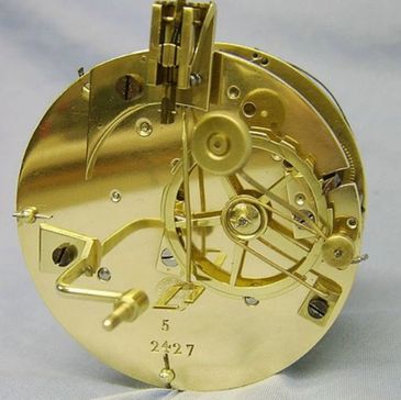 Close-up of a polished brass clock mechanism with intricate gears and levers.