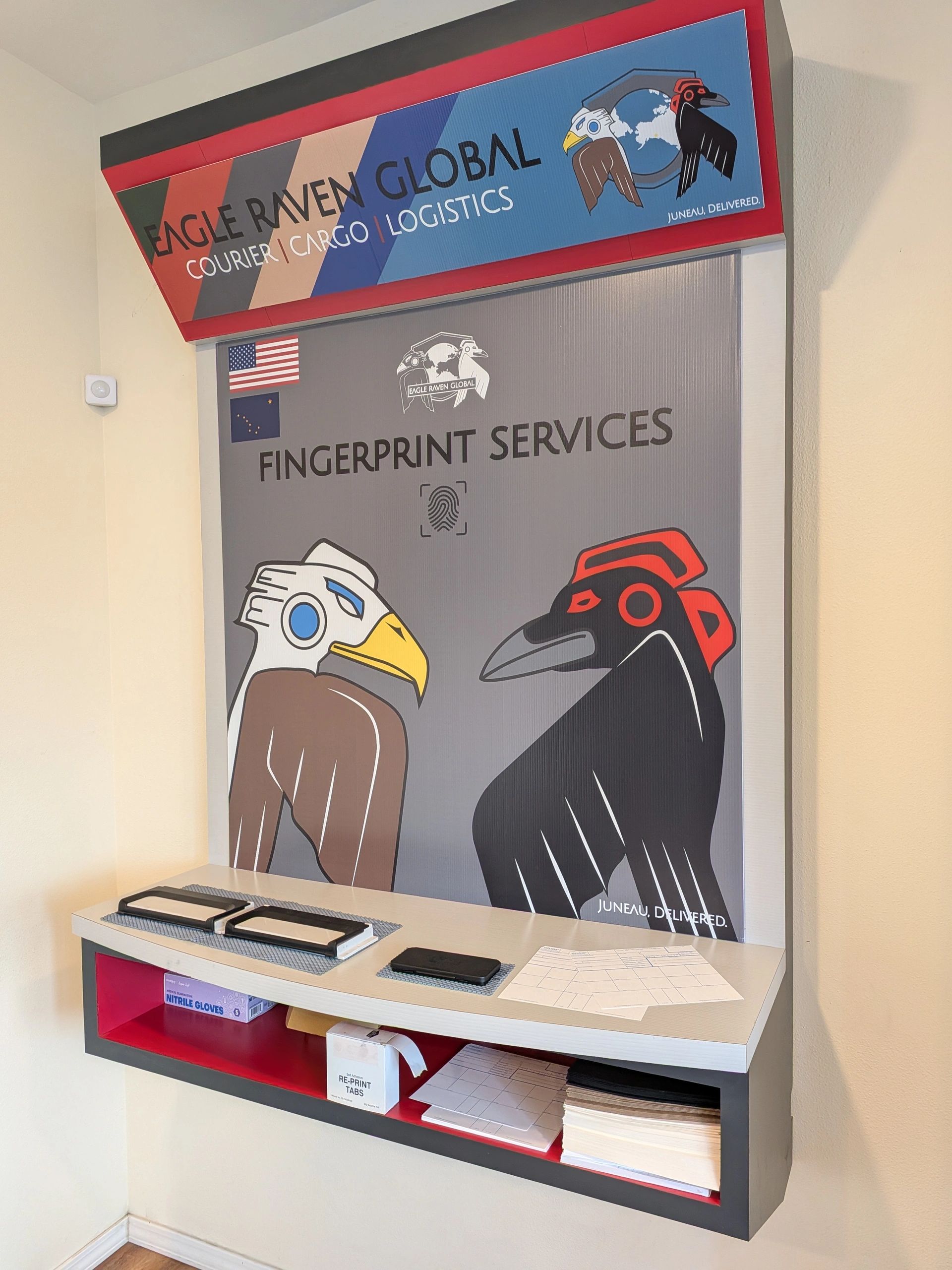 Fingerprint services kiosk with eagle and raven logos.