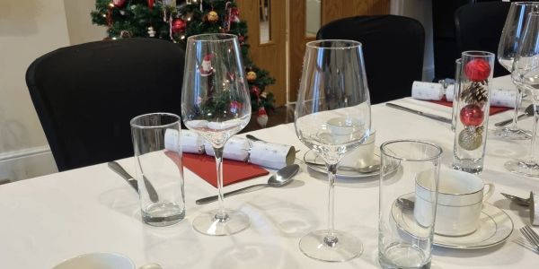 Holiday-themed table setting with wine glasses and decorations.