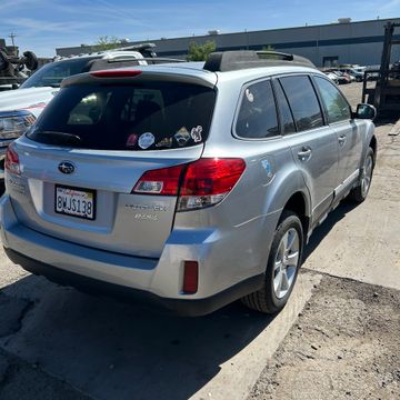 Silver Subaru Outback parked outside on a sunny day.