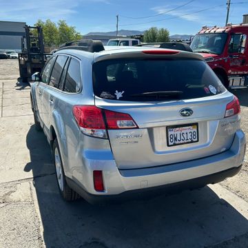 Silver Subaru Outback parked outdoors on a sunny day.