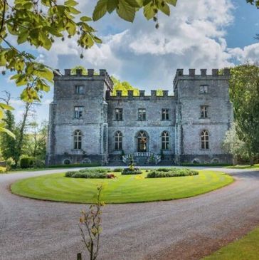 Clearwell Castle surrounded by vibrant green landscape.