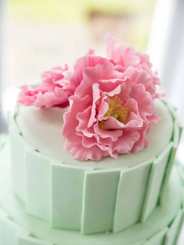 Emily Rose Wedding Cakes logo of a green wedding cake and pink flowers