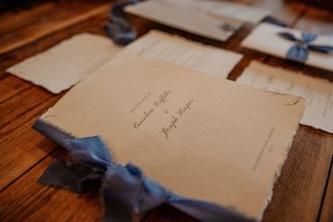 Wedding Order of Service booklet, with blue ribbon, lay on wooden