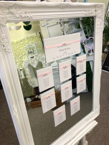 Wedding Table/Seating Plan with white lace and pink ribbons, mounted on a white mirrored Frame.