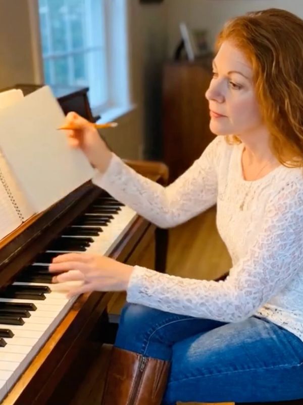 Woman composing music at piano.