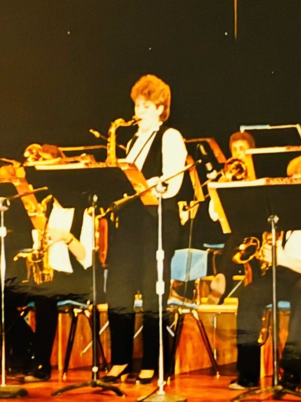 Musicians performing with saxophones on stage.