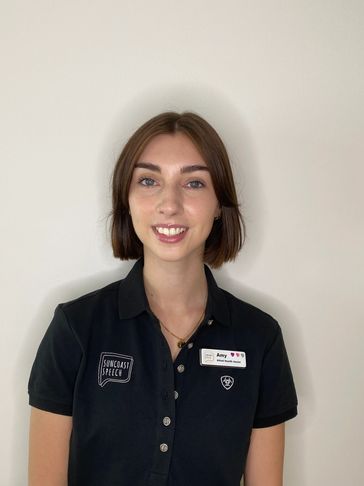 Amy - Allied Health Assistant is standing against a plain white wall