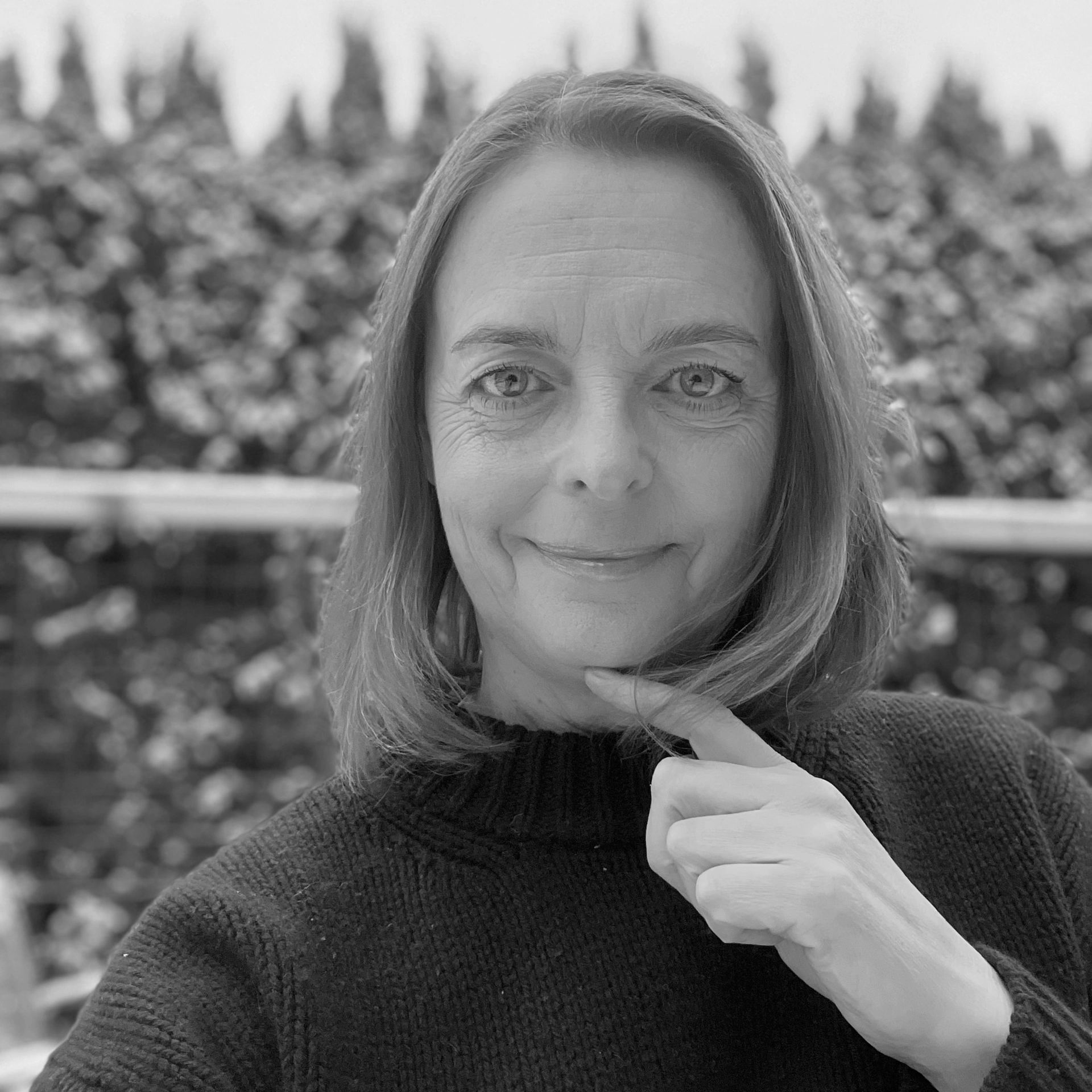 Leende kvinna med blå ögon utomhus i vintermiljö.