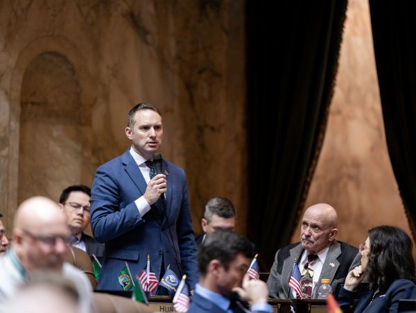 Man in blue suit speaking at a formal event.