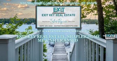 A dock leading to a lake with an Exit Key Real Estate sign.