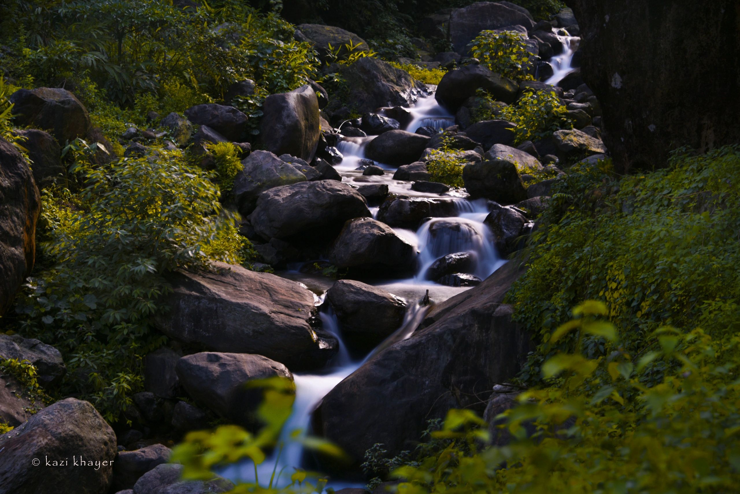 A small waterfall, captured in slow shutter, creating blurry motion. 