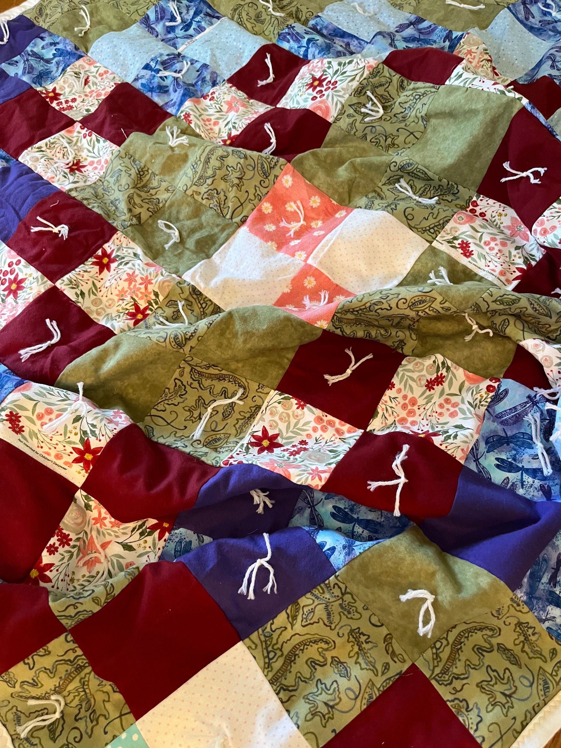 Colorful patchwork quilt with floral and patterned squares.