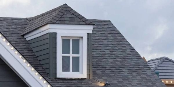 Dormer window on gray shingled roof.