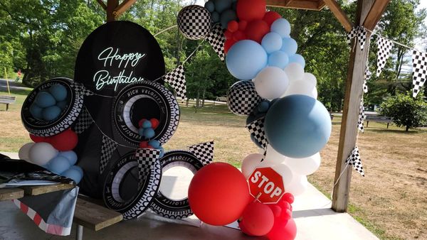 Race car theme birthday with tires, flag pendant and Chiara wall in a pavilion 