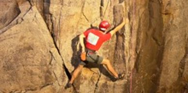 Man rock climbing on mountainside. Credit: juicer.com