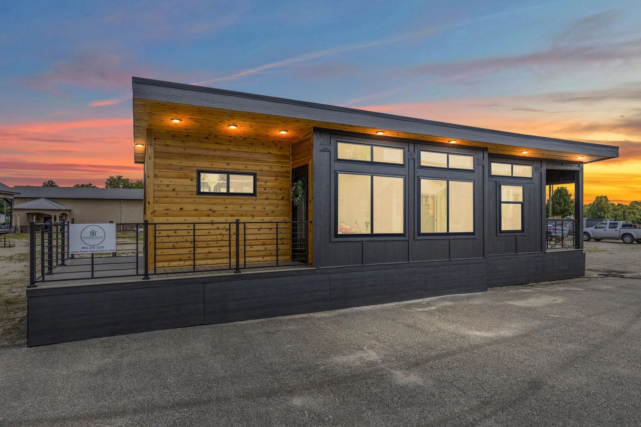 Modern tiny house with wood and black exterior at sunset.