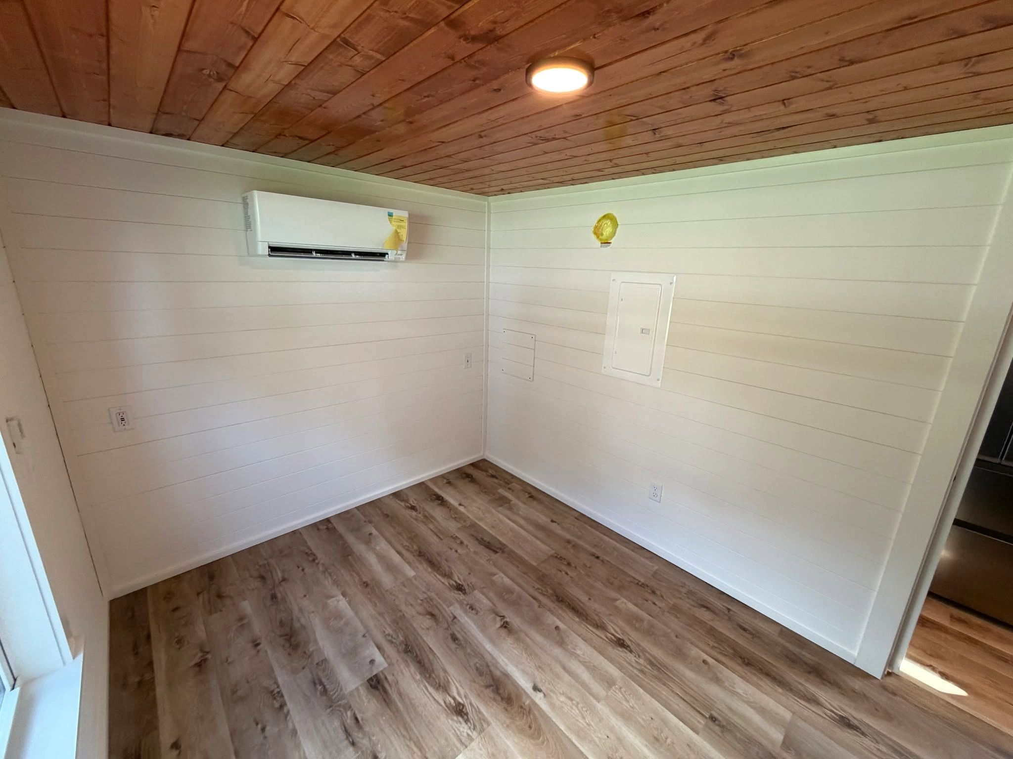 Empty room with wood ceiling and white walls.