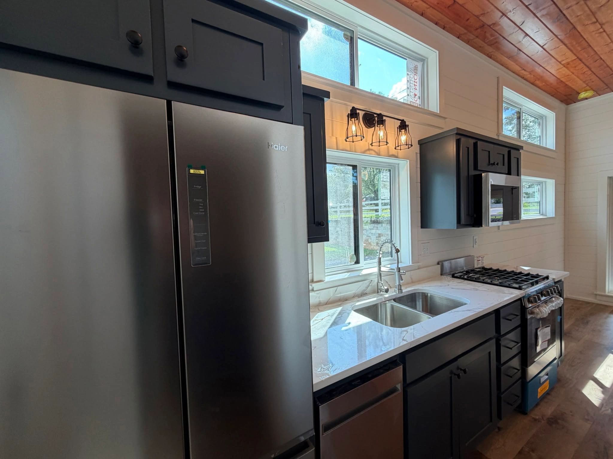 Modern kitchen with black cabinets and stainless steel appliances.