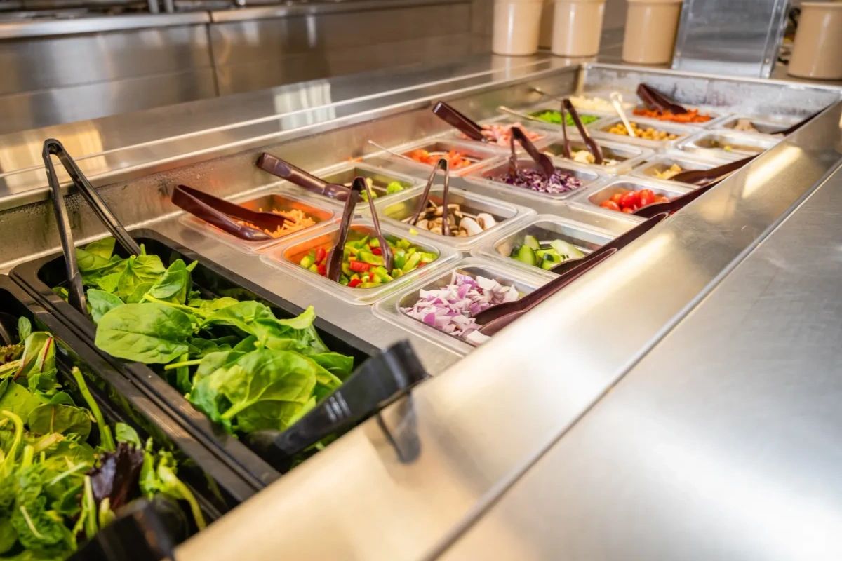 Fresh salad bar with various vegetables and greens.