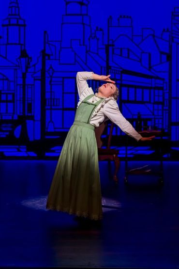 Actress performing a dramatic scene on stage.
