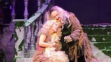 Two actors in a dramatic stage scene.