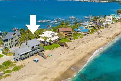 A beachfront house marked with a white arrow among oceanfront properties.