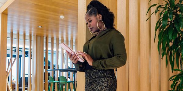 Woman in stylish outfit reading a book in a modern wooden interior, modern offices in London