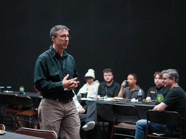 Man giving a talk to a seated audience in a casual setting.