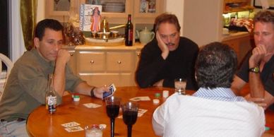 Robert Realmuto playing poker with friends around a kitchen table.