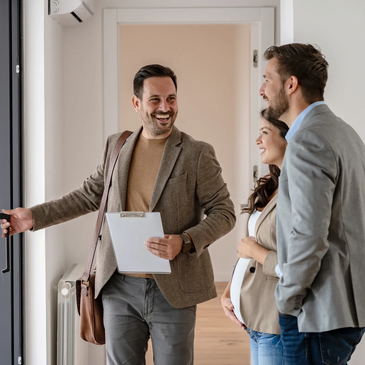 Real estate agent showing a smiling couple a new home.