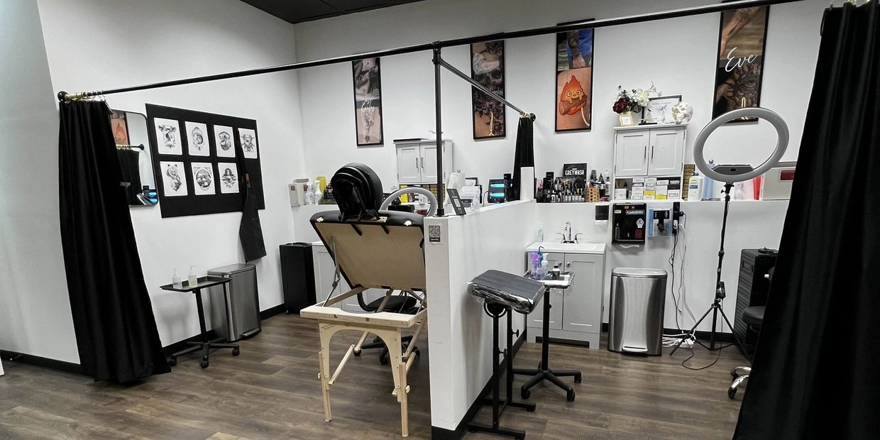 Modern tattoo studio with clean, organized workstations and artistic wall decor.