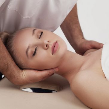 Woman receiving a relaxing head massage from a therapist.