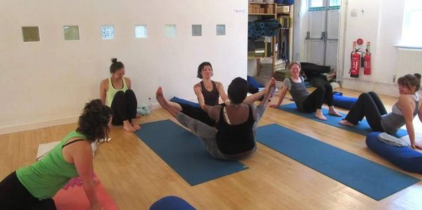 A group of women practicing yoga in a bright studio.