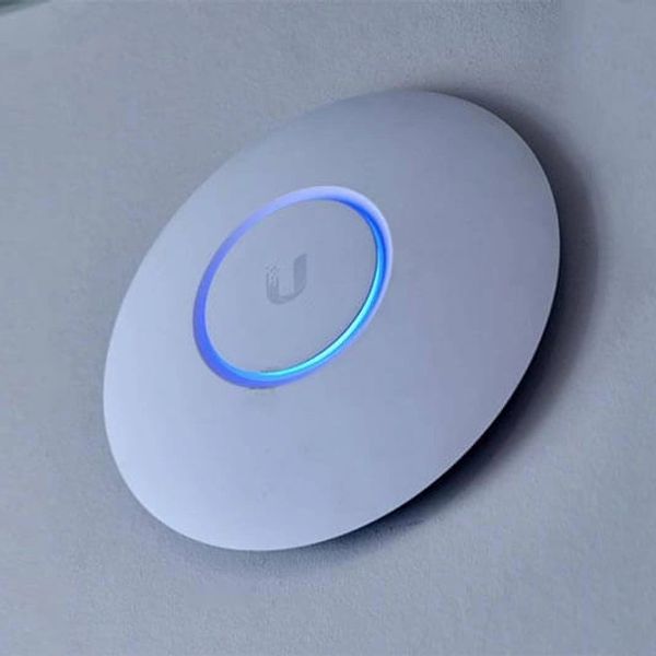 Ceiling-mounted wireless access point with blue light.